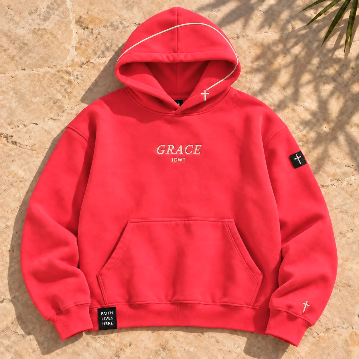 The Grace Arc Hoodie in vibrant watermelon pink, with ivory hood piping and subtle cross details